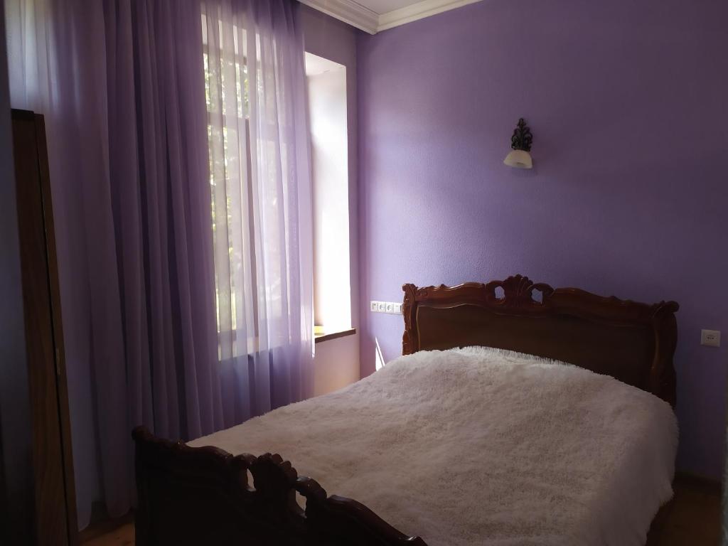 戈里斯Verishen Guest House B&B的一间卧室配有一张紫色墙壁和窗户的床