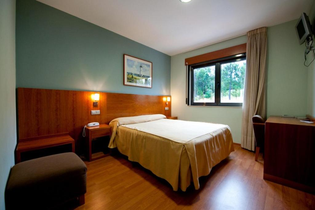 波尔托辛Hotel O Noso Portosin的酒店客房设有床和窗户。