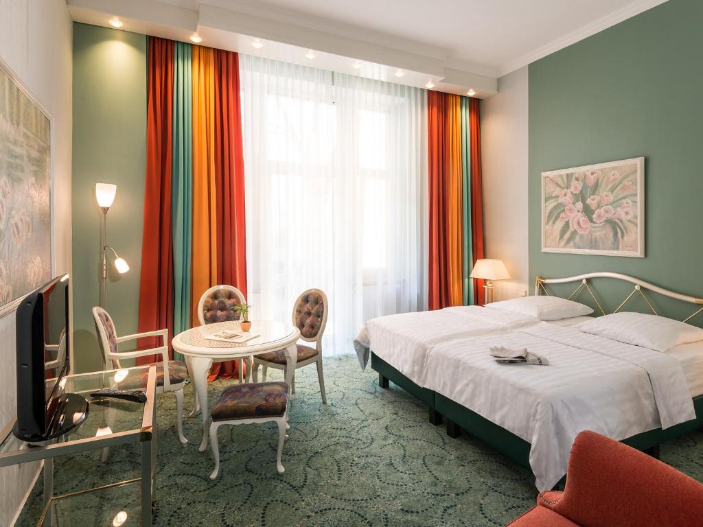 美因河畔法兰克福帕尔门霍夫酒店的酒店客房带一张床、一张桌子和椅子