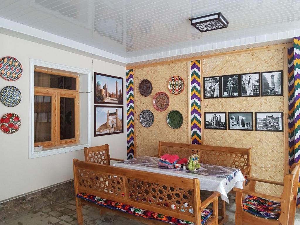 布哈拉Guest house IBROHIM حلال的一间设有桌子和一些盘子的用餐室