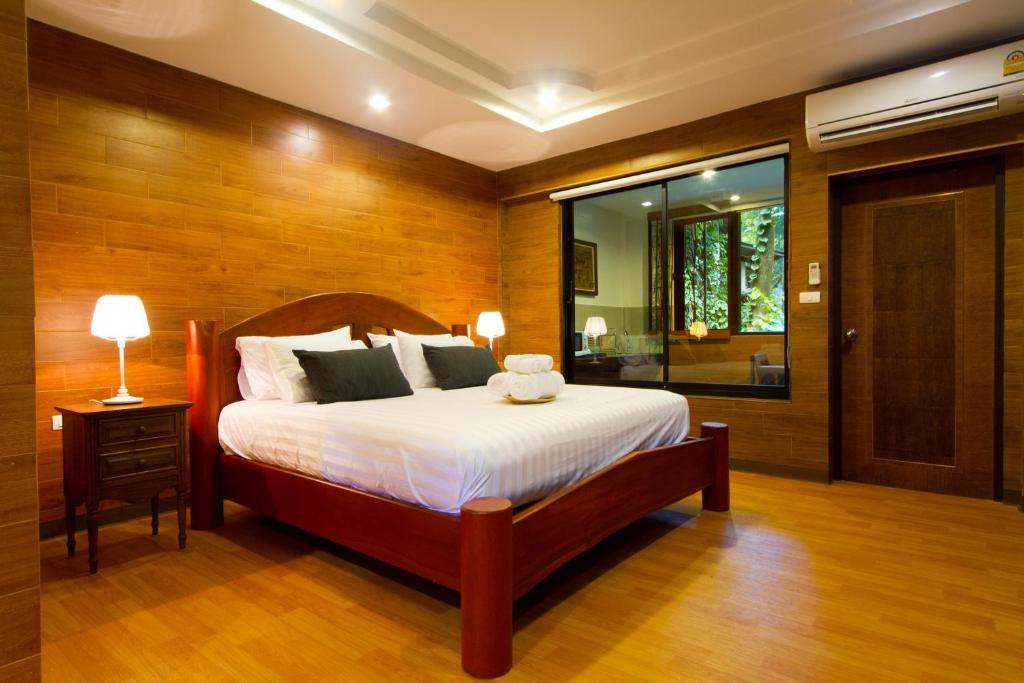 坤西育府Namtok Sarika Resotel的一间卧室设有一张大床和一个窗户。