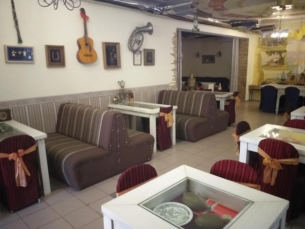 比尔戈罗德-德尼斯特罗夫西基嘉年华酒店的一间配有沙发的等候室和墙上的吉他