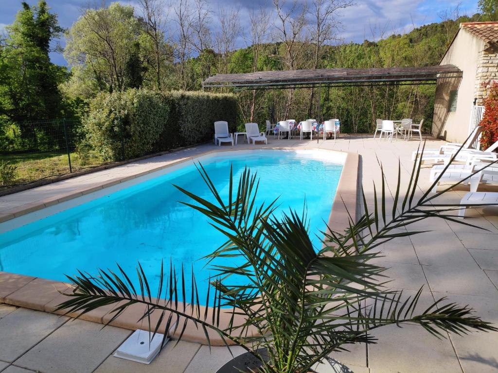 赛尼翁Villa Les Carlets的后院的游泳池,配有桌椅