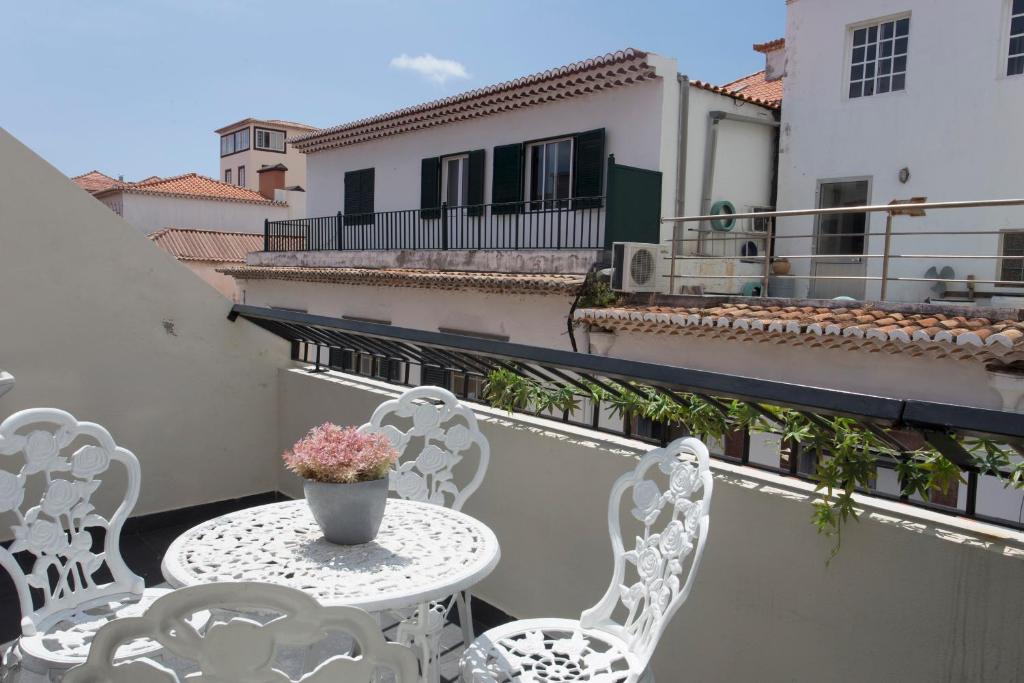 丰沙尔Antonella Home Funchal的阳台上配有白色的桌椅