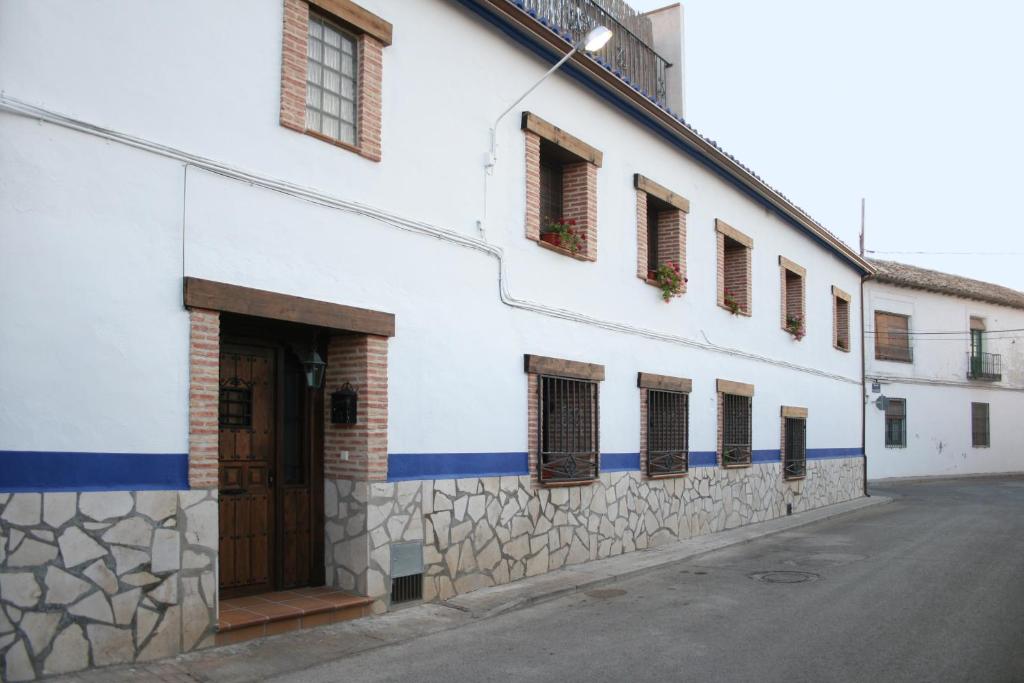 Villarrubia de Santiago卡萨农村拉波萨达德尔弗朗西丝乡村民宿的白色的建筑,设有棕色的门和窗户
