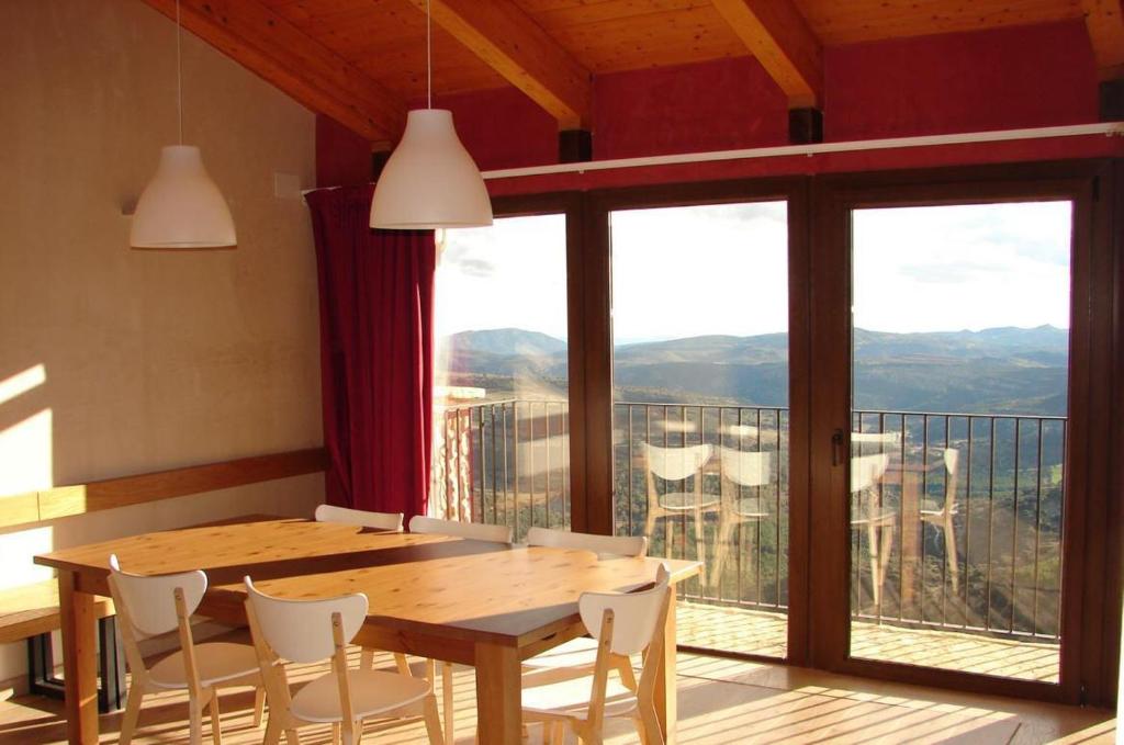 Ares del MaestreCasa Rural Virginia的一间带桌椅的用餐室和一个阳台