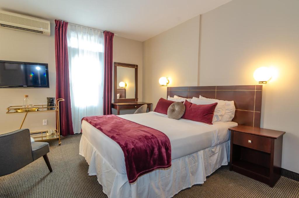 蒙特利尔Maison Cartier Montreal的酒店客房配有一张带红色枕头的大床