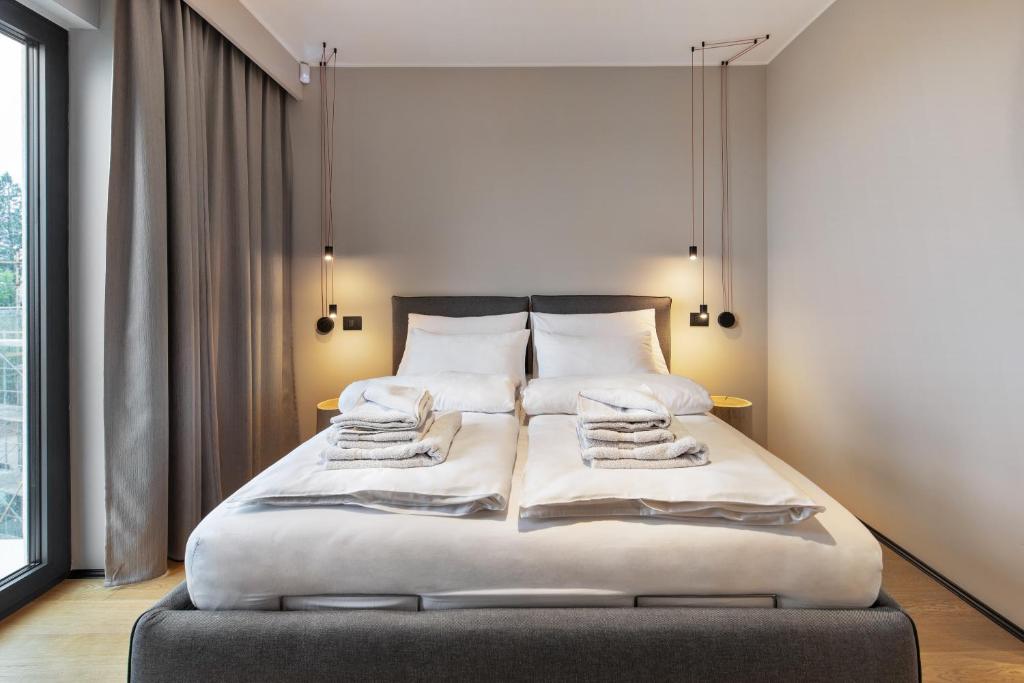 马图利FourRoomotel的一间卧室配有带白色床单和枕头的床。