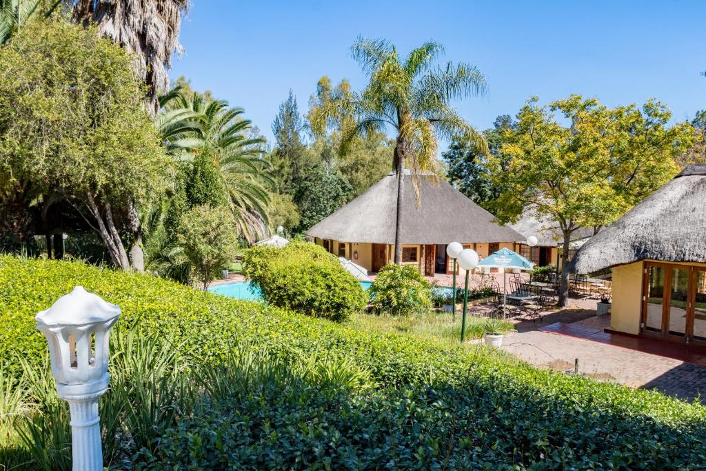 拉塞利亚Shumba Valley Lodge的享有带游泳池和树木的度假村景色