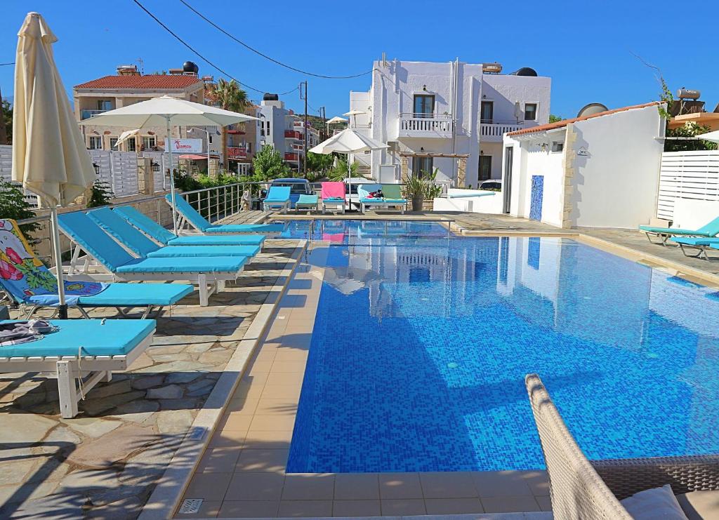 普拉塔尼亚斯Sonio Beach - Que Bella Collection的一个带蓝色躺椅和遮阳伞的游泳池