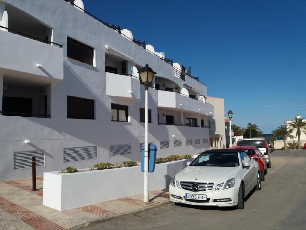 卡沃内拉斯Frente al Mediterráneo en Carboneras的停在大楼前的白色汽车
