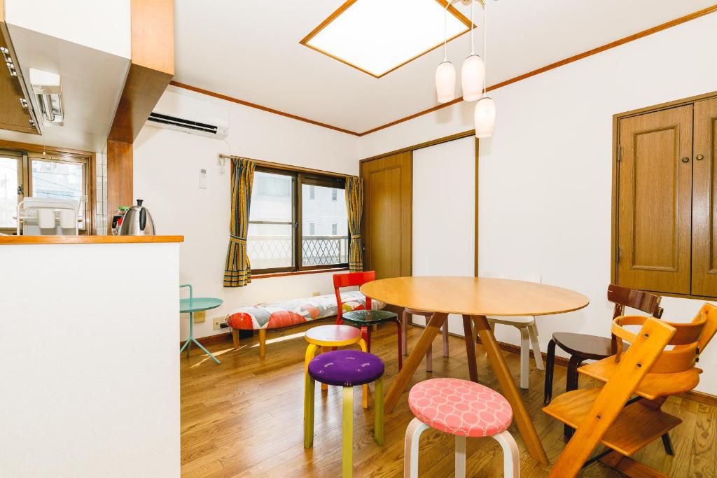松本1組貸切りの宿 Popotel 2 -NIKAI 二階-的厨房以及带桌椅的用餐室。