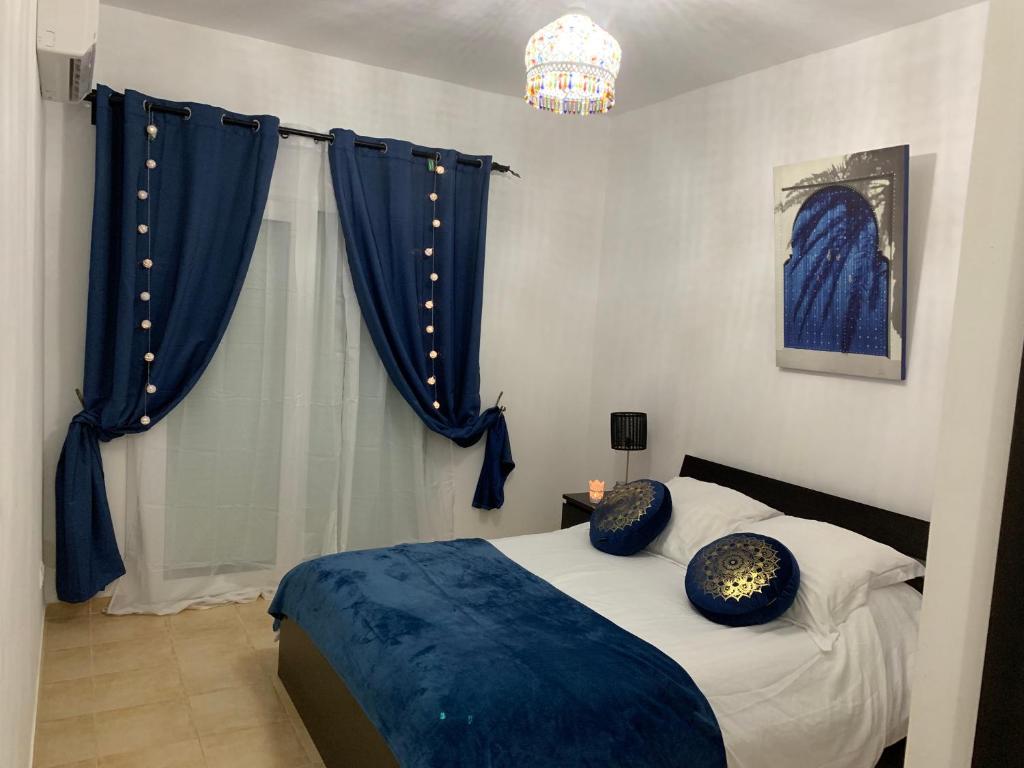 萨伊迪耶Oriental Dary Al Waha Marina Saidia的一间卧室配有一张带蓝色枕头的床。