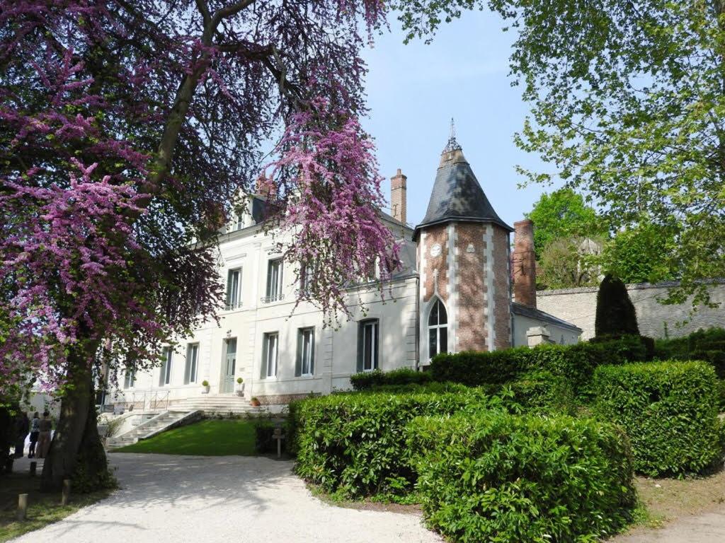 拉·寿塞·圣·威Château des Basses Roches的一座白色的大房子,有塔楼和树木
