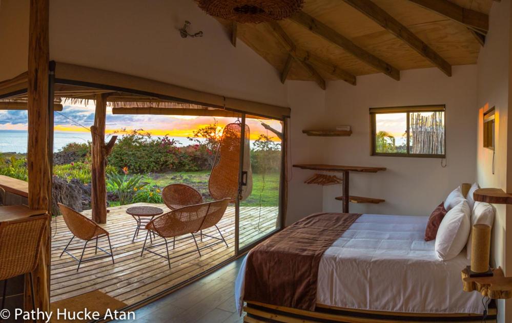 安加罗阿科纳兴亚旅馆 的一间卧室配有一张床,庭院配有椅子
