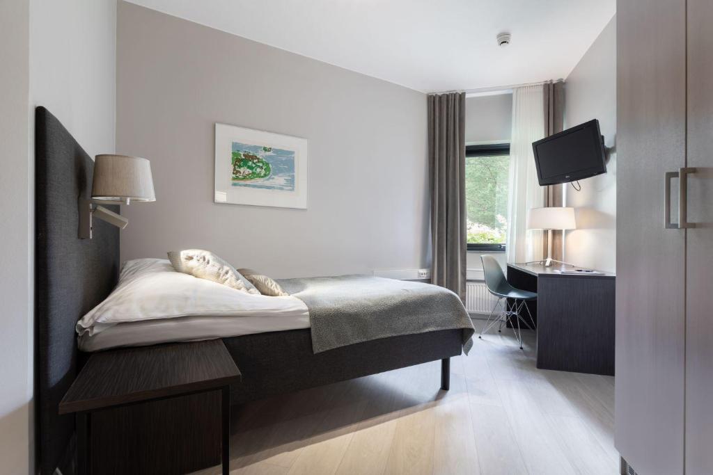 基尔科努米迈克会议酒店的一间卧室配有一张床、一张书桌和一台电视