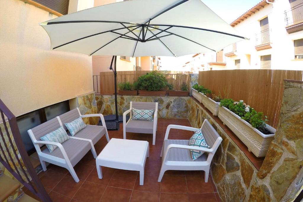 LanzahitaCasa en el valle del tietar的庭院配有桌椅和遮阳伞。