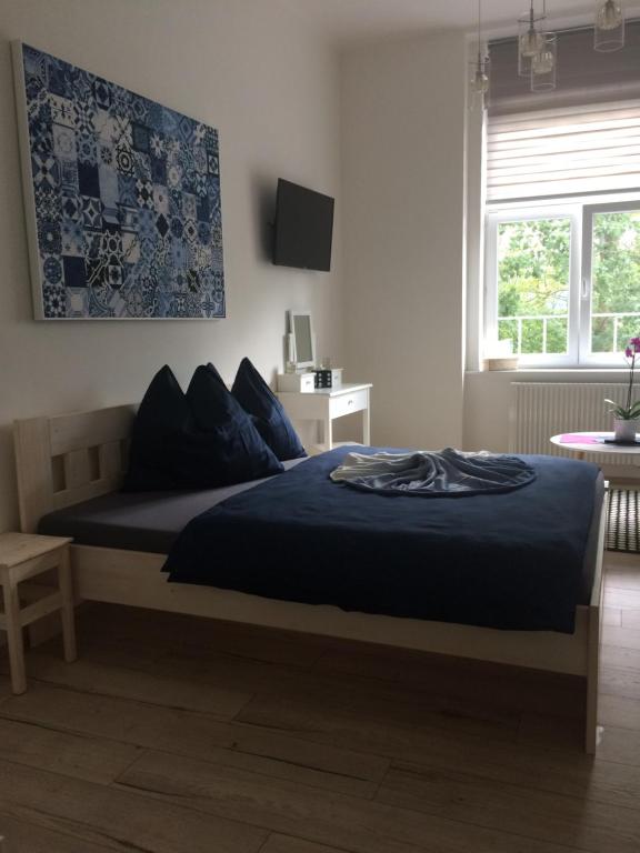 卡罗维发利Apartmán nad Imperiálem的一间卧室配有一张带蓝色床单的床和一扇窗户。