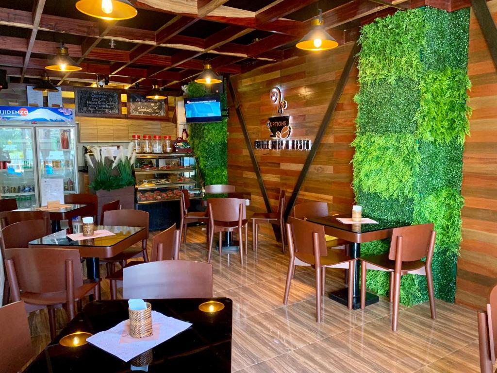 达沃市Davao Persimmon Suites的一间带桌椅和绿色墙壁的餐厅