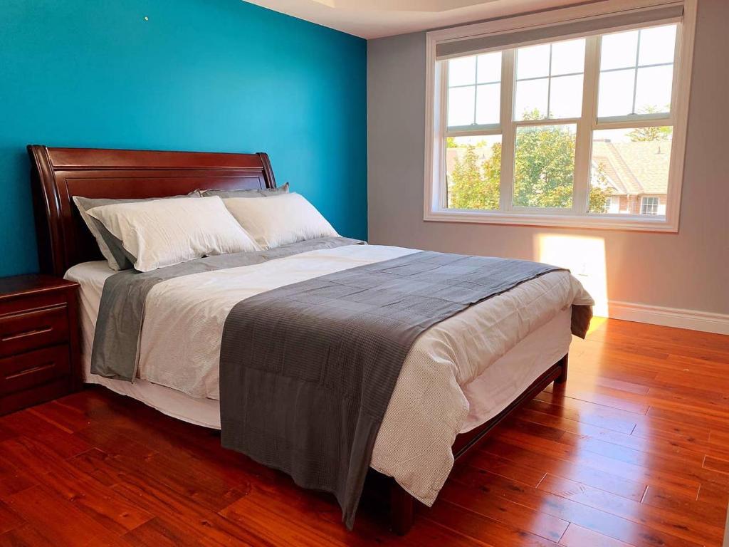 多伦多Nice rooms with private bath in Mid Town Toronto的一间卧室设有一张蓝色墙壁的大床