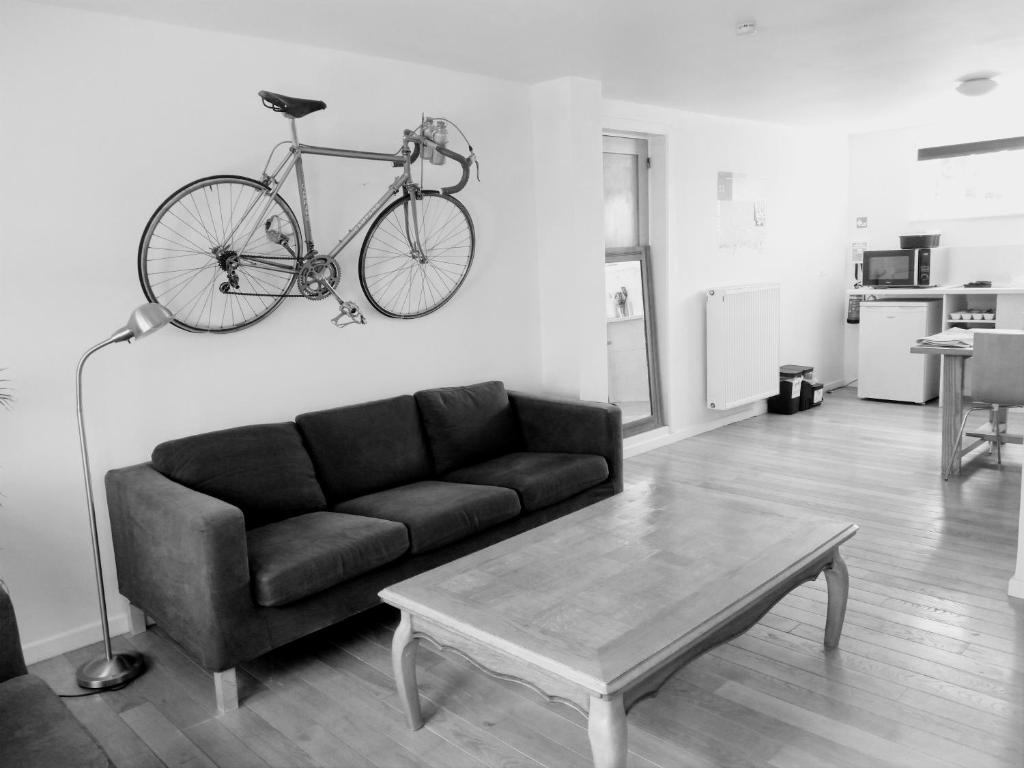 奥德纳尔德Studio Flandrien的客厅配有沙发,墙上挂着自行车
