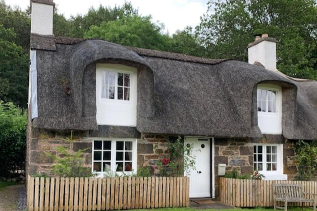 阿伯费尔迪Glencroft A Fairytale Highland Cottage的一座带茅草屋顶的古老石头房子