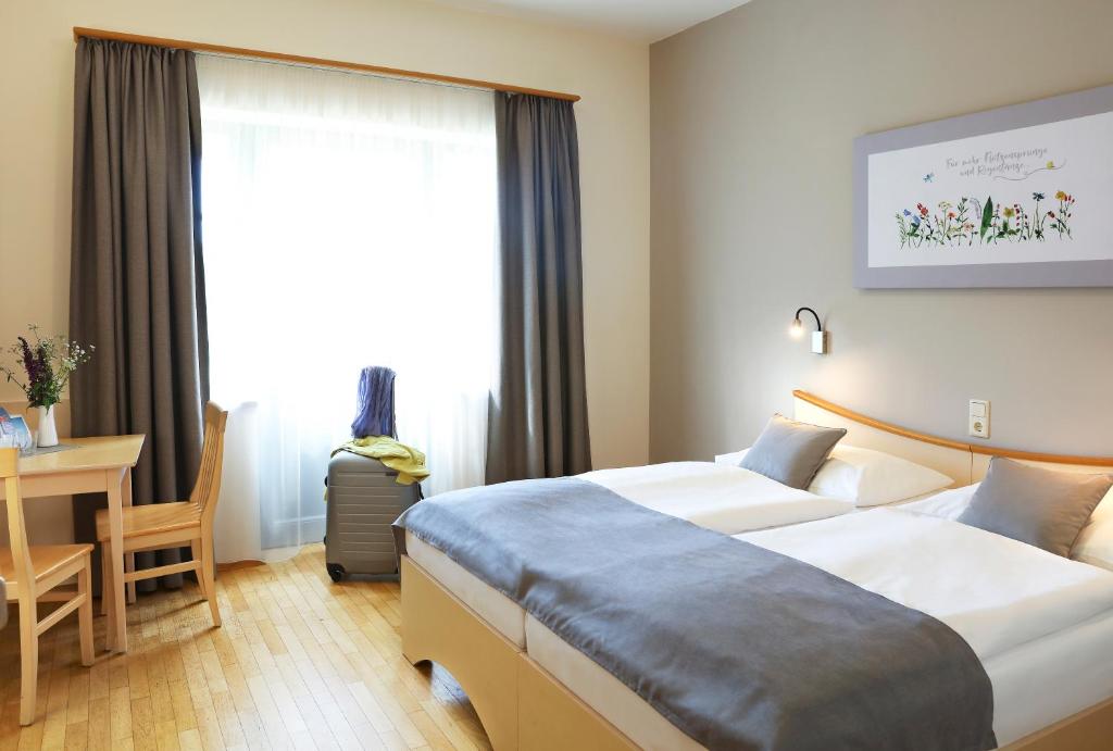 珀劳JUFA Hotel Pöllau - Bio Landerlebnis的酒店客房配有两张床和一张书桌