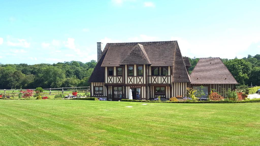 Saint-Pierre-AzifL'Herbe aux Vaches的一个大房子,有大片草地