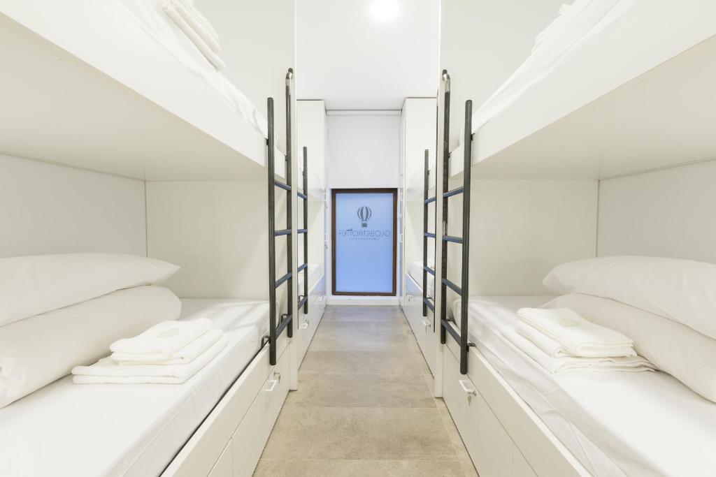 莱昂Globetrotter Hostel的一间设有白色床和蓝色门的房间