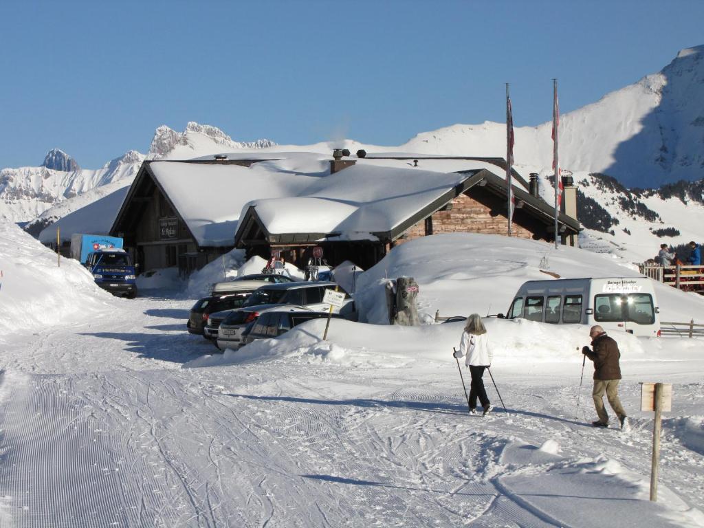 雷克罗塞勒里莱斯全景宾馆及餐厅的两人在小屋前的雪地滑雪