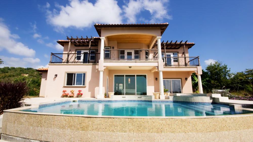 维约堡Emerald Vista Villa的一座房子前面设有一个大型游泳池
