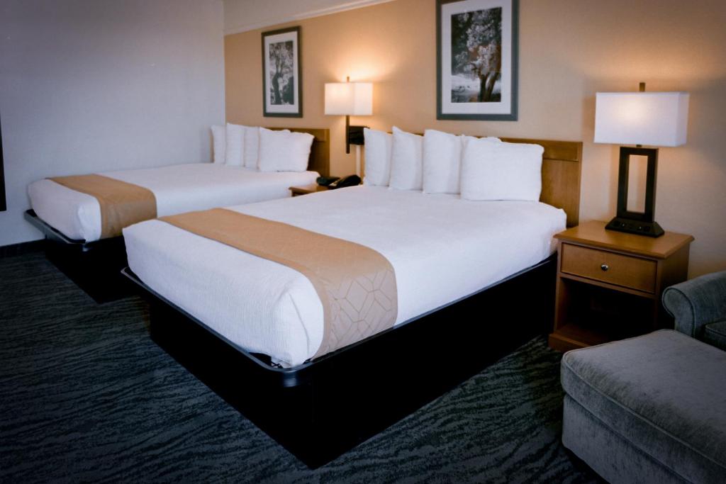 卡顿伍德Pines Inn & Suites的酒店客房,设有两张床和一张沙发