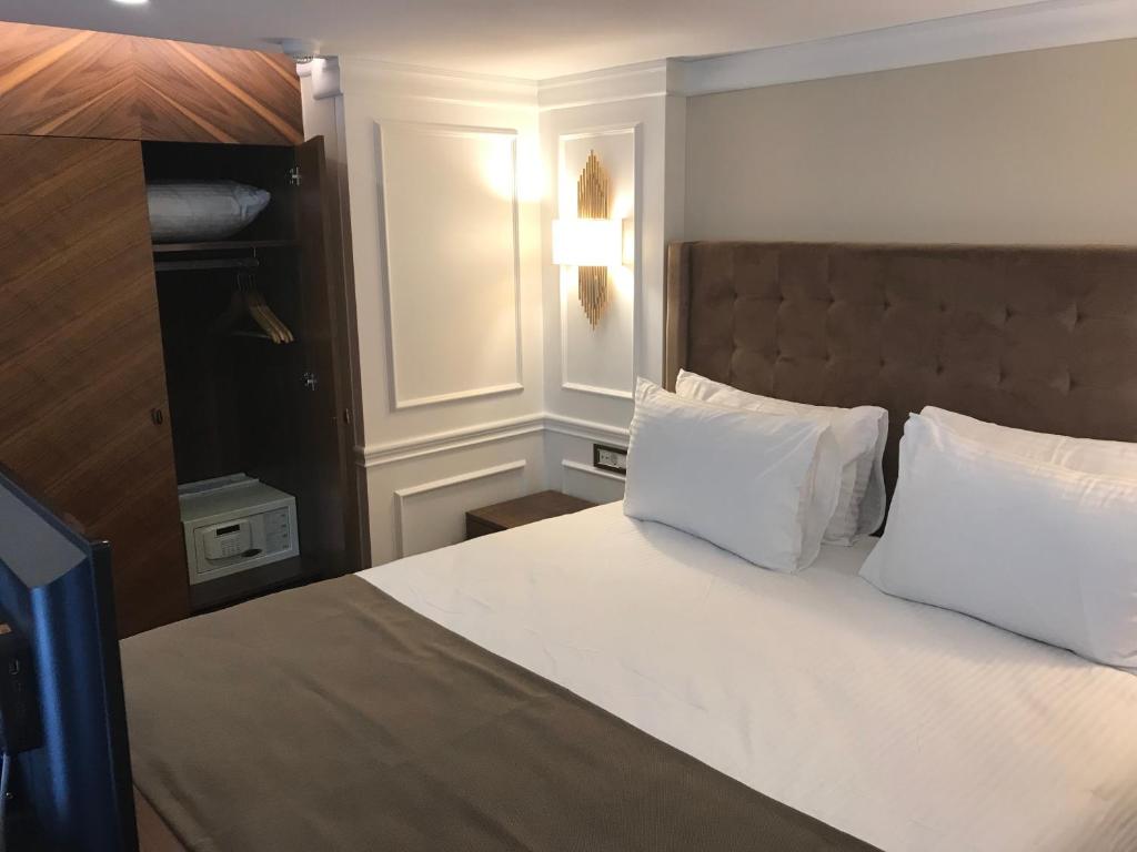 伊斯坦布尔Old Port Hotel Suit的卧室配有带白色枕头的大床