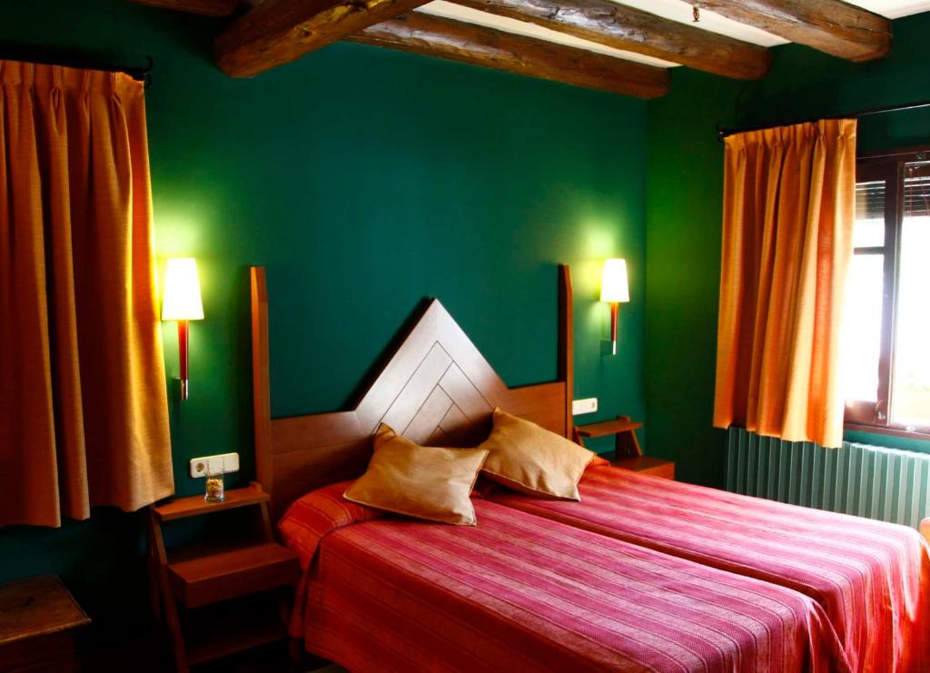 Areu瓦尔费雷拉酒店的一间拥有绿色墙壁的卧室和一张铺有红色床单的床