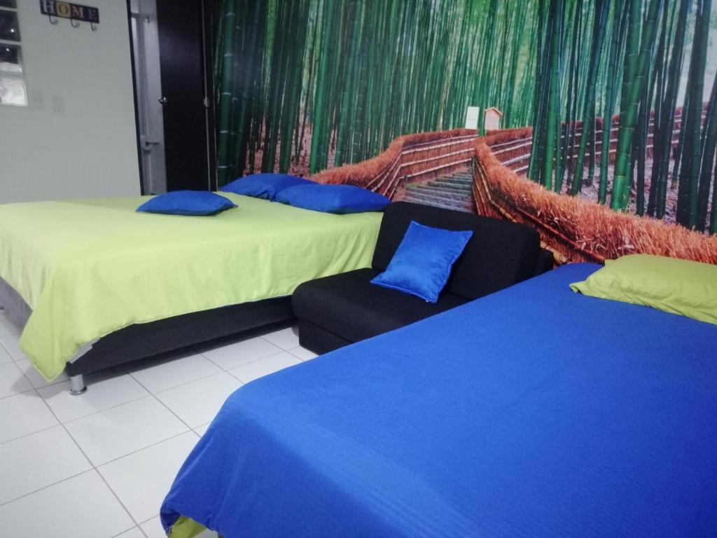 麦德林APARTA ESTUDIO 7051的两张带蓝色枕头的床和一把椅子