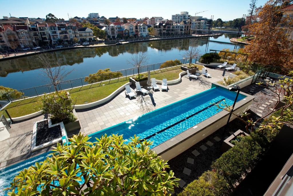珀斯East Perth Suites Hotel的水体旁边的游泳池