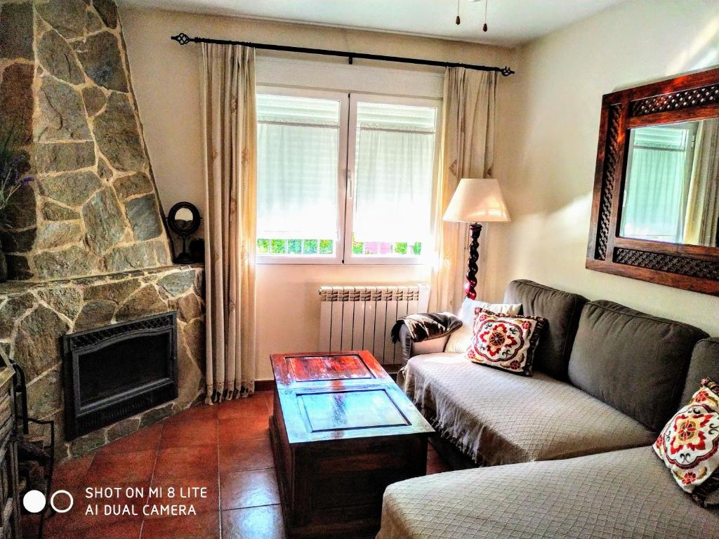 洛索亚Casa Sierra Norte Madrid的带沙发和壁炉的客厅