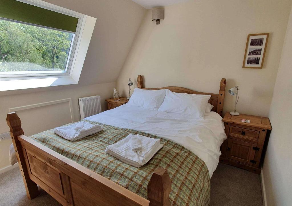 多尔威泽兰Plas Penaeldroch Manor的一间卧室配有一张带白色床单的床和一扇窗户。