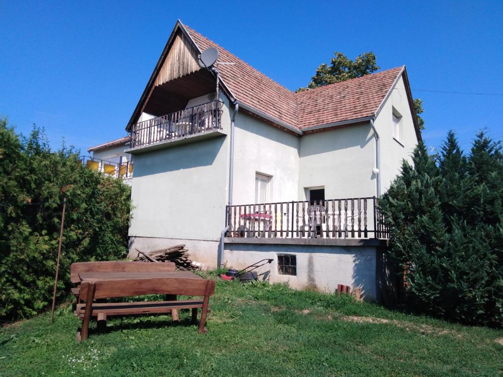 赞考VIL'LAGUNA Apartment with view of Balaton的带阳台和长凳的白色房屋