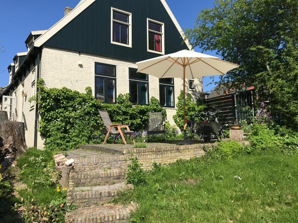 德瓦尔Pastorie De Waal的院子里带雨伞和椅子的房子