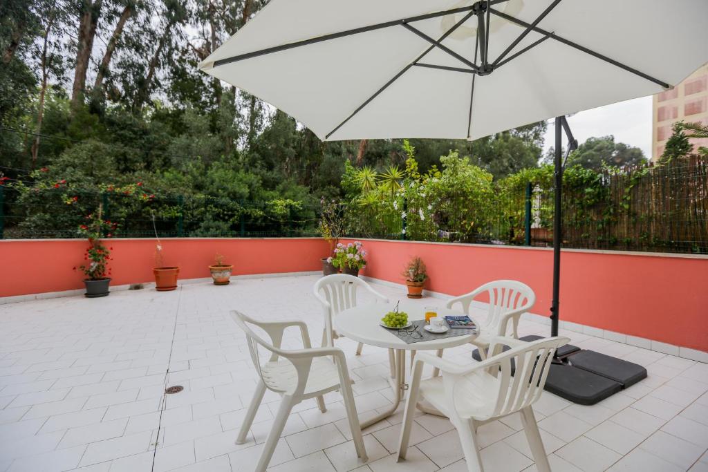 里斯本Like-home Bright Benfica Apt的庭院配有白色的桌椅和遮阳伞。