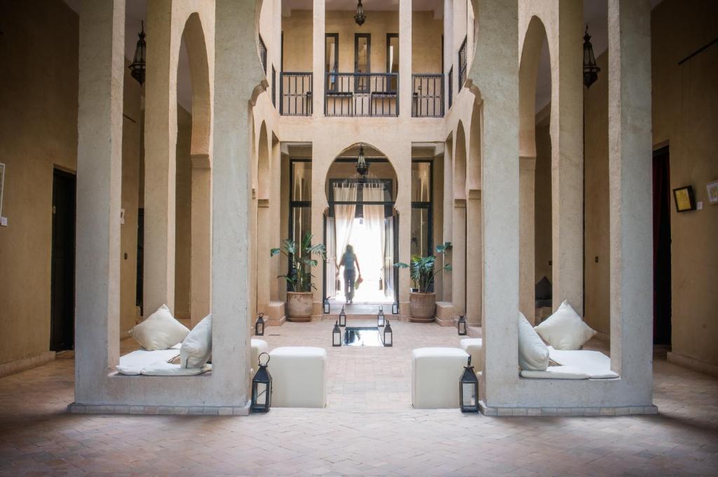 瓦尔扎扎特达查玛酒店的走廊上设有白色椅子,远处有一个人