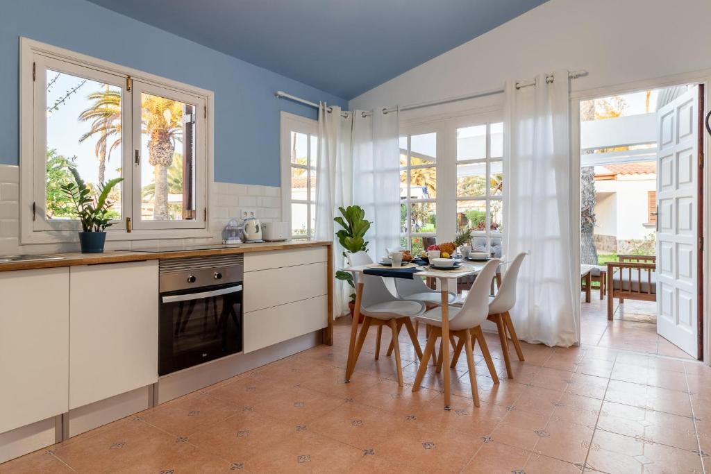 圣巴托洛梅Flatguest Villa Yaiza PISCINA EN REFORMAS的厨房配有白色橱柜和桌椅