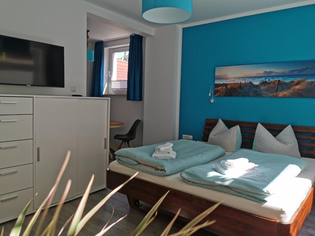 瓦尔内明德Gästehaus Twee Linden的一间卧室配有一张蓝色墙壁的床
