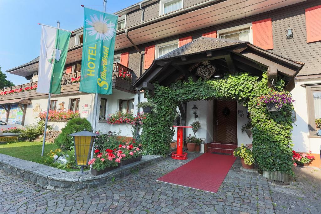 欣特察尔滕斯尔博迪斯特尔酒店的一座建筑,前有红门和鲜花