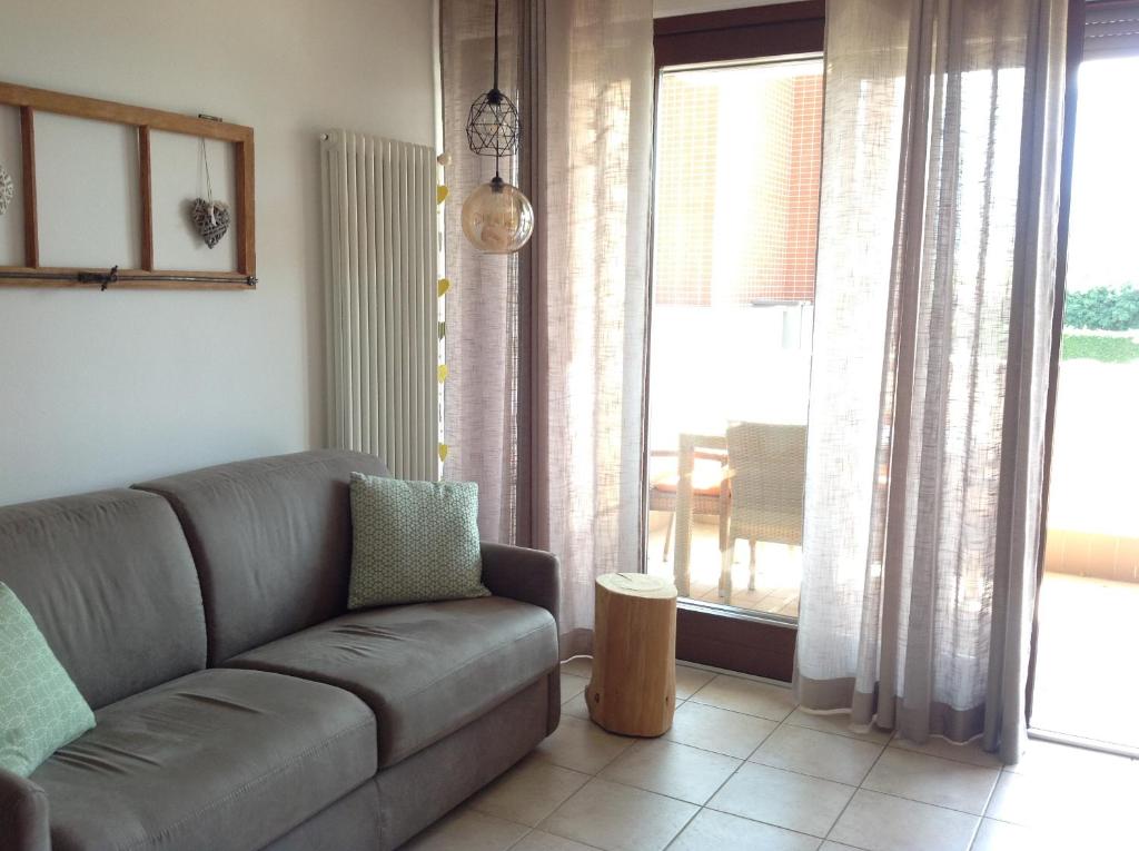 拉伊韦斯HOME DI CRISTINA的带沙发和大窗户的客厅