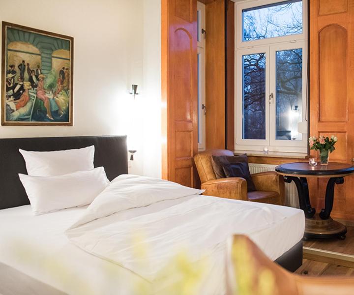 慕尼黑Hotel Ritzi的一间卧室配有一张床、一张桌子和一个窗户。
