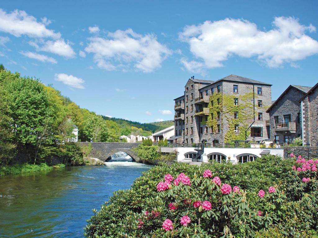 纽比桥白水酒店及Spa中心的一座有桥和鲜花的城镇中的河流