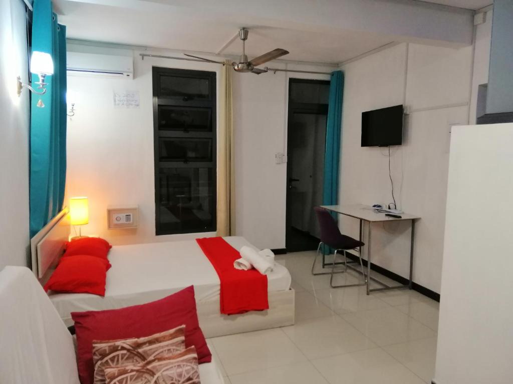 马埃堡Residence Les Bambous B&B的卧室配有白色的床和红色枕头