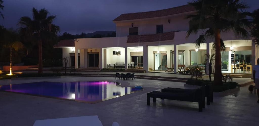 阿加迪尔Villa blanche piscine chauffée的一座晚上设有游泳池的房子
